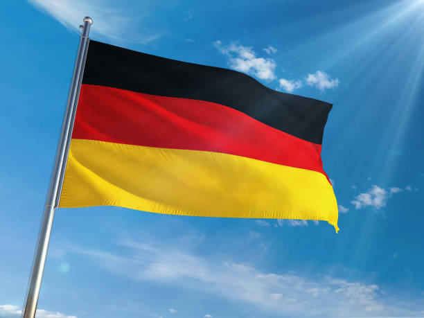 istock Germany National Flag Waving on pole against sunny blue sky background. High Definition 1128962997