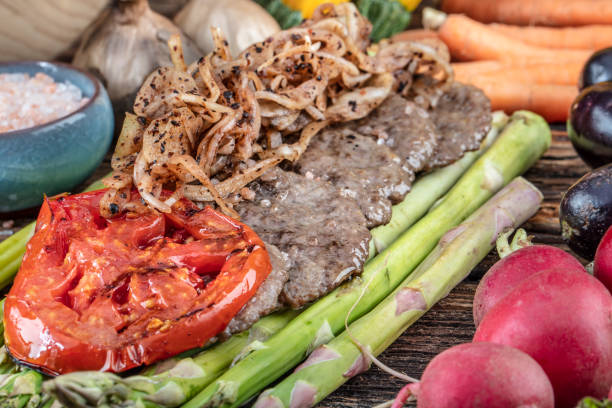 istock Turkish meatballs, (Turkish Food Kofte or Kofta), created background with vegetables, Meatballs on asparagus. 1128963023