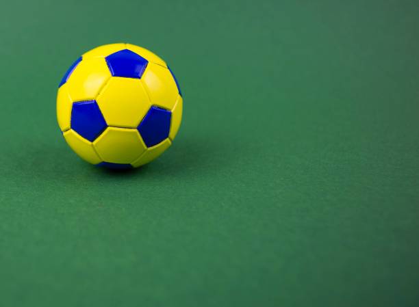 istock soccer ball on a green background, with space for adding text 1128963045