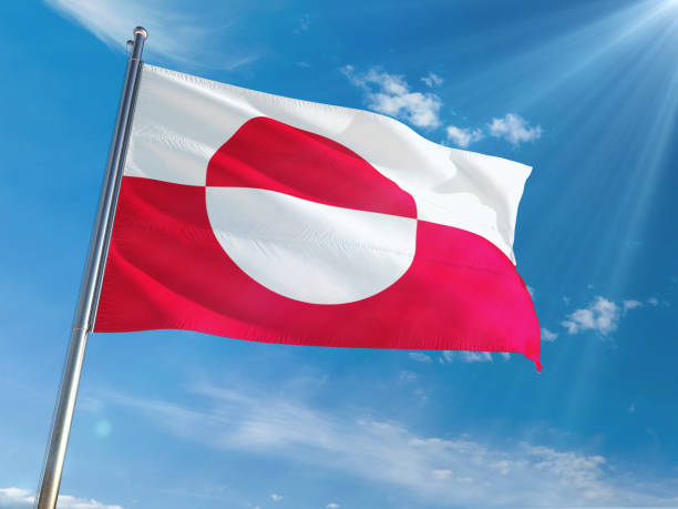 istock Greenland National Flag Waving on pole against sunny blue sky background. High Definition 1128963321