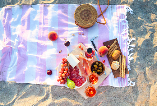 Picnic outdoor with rose wine fruits, meat and cheese