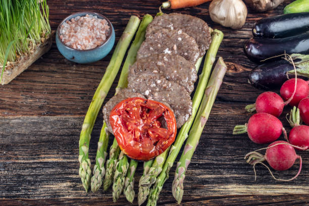istock Turkish meatballs, (Turkish Food Kofte or Kofta), created background with vegetables, Meatballs on asparagus. 1128964051