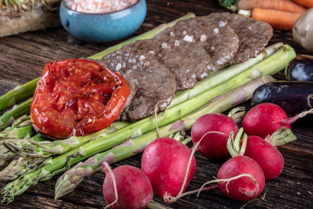 istock Turkish meatballs, (Turkish Food Kofte or Kofta), created background with vegetables, Meatballs on asparagus. 1128964429