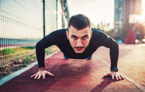 it's time for exercise. young sportsman doing push ups. sport, fitness, street workout concept - exercising men push ups muscular build imagens e fotografias de stock