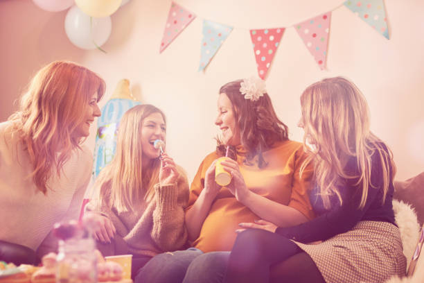 mujer embarazada celebrando bebé ducha partido con los amigos. - baby shower women home interior indoors fotografías e imágenes de stock