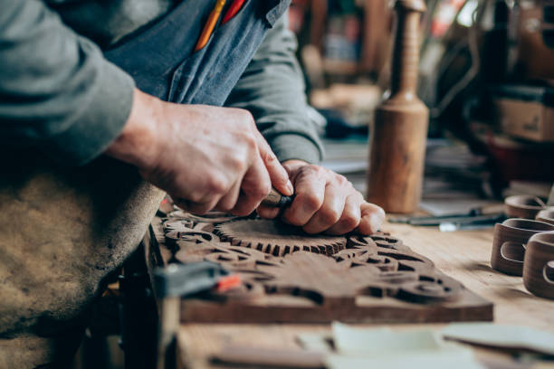Close up of a carpenter hands working with a chisel and carving tools