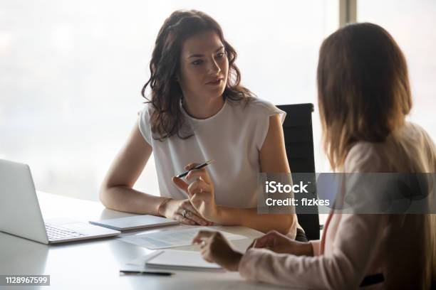 Foto de Duas Empresárias De Graves Diversas Falando Trabalhando Juntos No Escritório e mais fotos de stock de Discussão