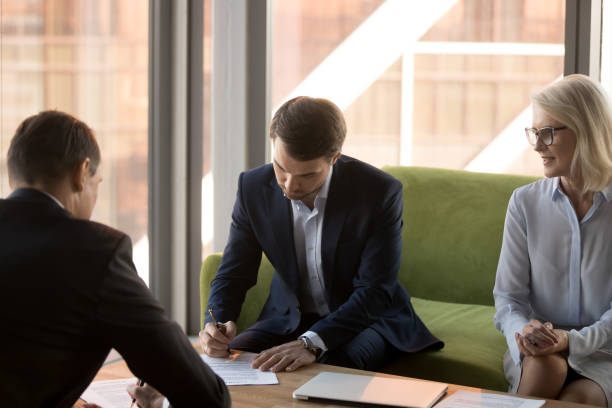 istock Two business partners signing papers contracts at meeting 1128967600