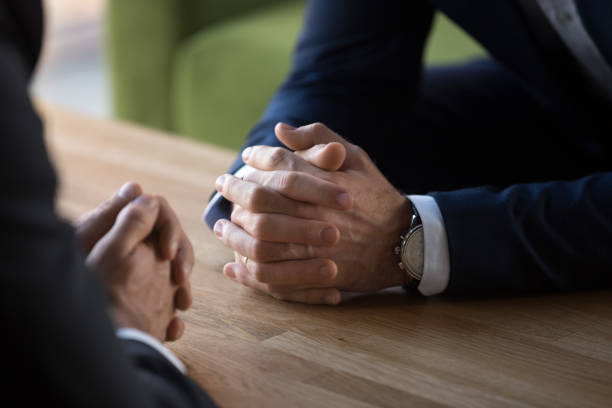 Clasped male hands of two businessmen negotiating at table Clasped male hands of two businessmen negotiate at table, hr recruiter making hiring decision at difficult job interview, opponents dialogue debate, business confrontation challenge concept, close up confrontation stock pictures, royalty-free photos & images