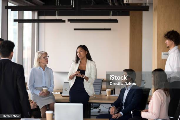Serious Asian Coach Speaking At Diverse Corporate Group Meeting Stock Photo - Download Image Now