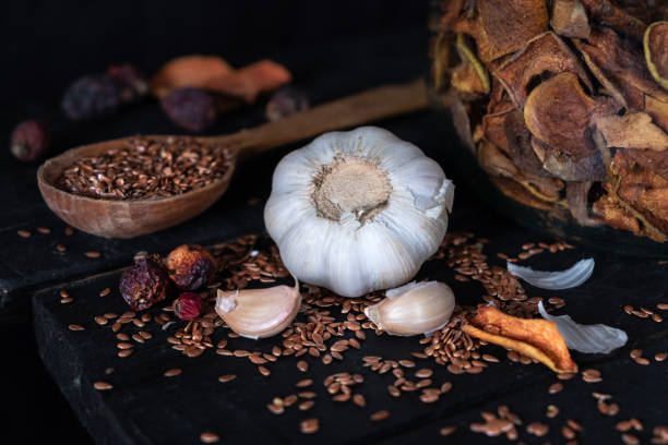 istock Garlic, dried fruit and seeds in dark rustic background. 1128968038