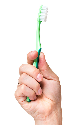 Man hand holding toothbrush isolated on white background. New tooth brush in hand - dental care.