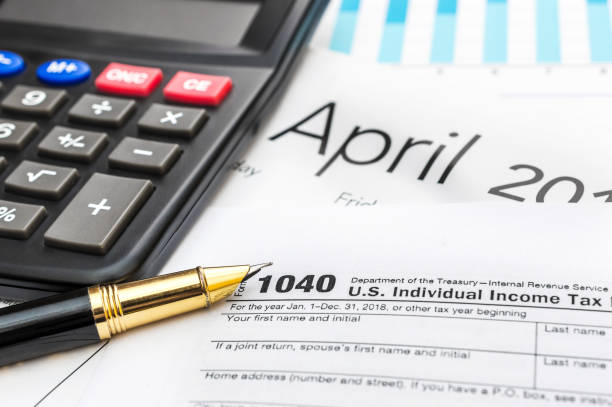 istock Tax form with pen, calculator and calendar. 1128971499