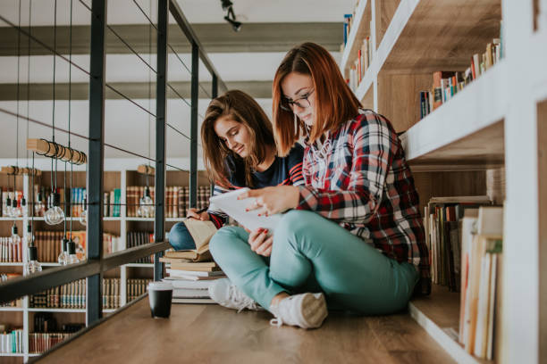 istock Two teenagers study in the library 1128971559