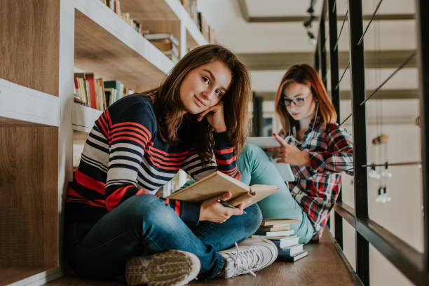 istock Two teenagers study in the library 1128971794