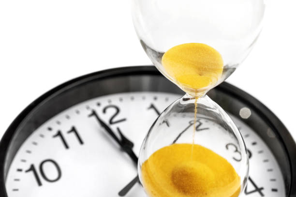 istock Hourglass on office clock. Close up. Isolated on white. 1128972015