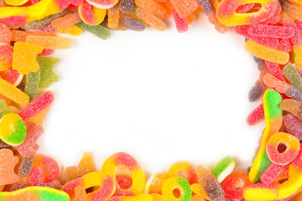 istock Frame of assorted gummy candies isolated on white. Top view. Space for text or design. 1128972938
