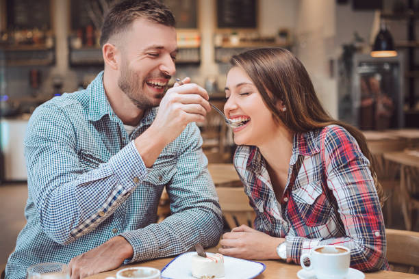 istock Heterosexual couple eating with spoon cake feeding each other and smiling 1128973869