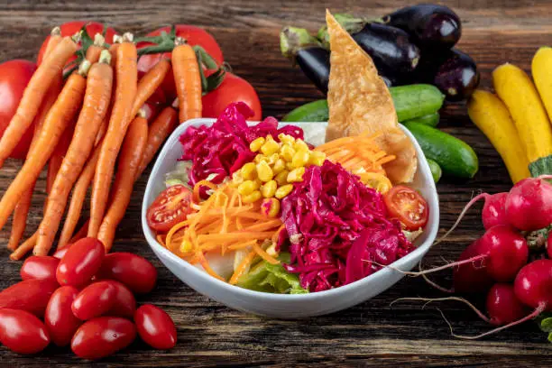 Carrot and veggies salad with lettuce, corn, red-cabbage, healthy homemade vegan food, vegetarian diet, vitamin snack.