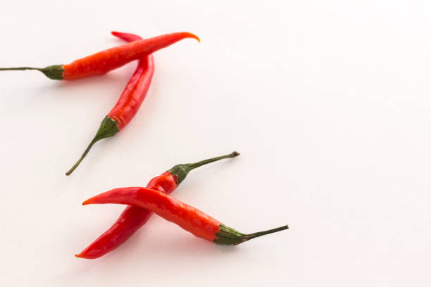 istock Red chili pods with green stems on white background. Top view 1128976259