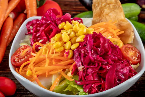 Carrot and veggies salad with lettuce, corn, red-cabbage, healthy homemade vegan food, vegetarian diet, vitamin snack.
