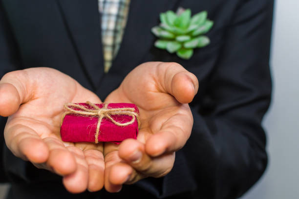 istock boy in a suit holding a gift box 1128976399