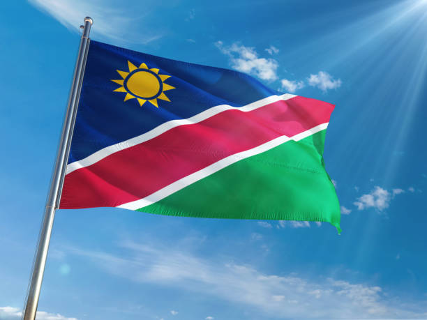 istock Namibia National Flag Waving on pole against sunny blue sky background. High Definition 1128977329