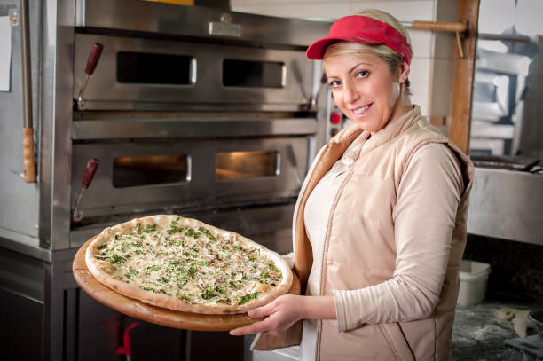 istock Chef remove fresh italian pizza from stove 1128977510