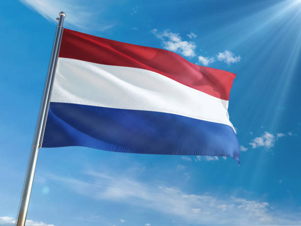 istock Netherlands National Flag Waving on pole against sunny blue sky background. High Definition 1128977516
