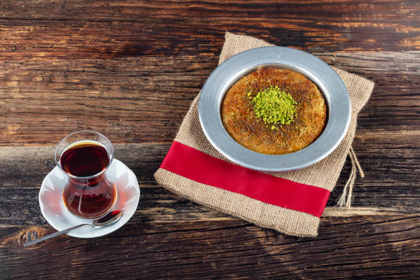 deliciosa sobremesa turca tradicional, kunefe com pistache e chá. - künefe - fotografias e filmes do acervo