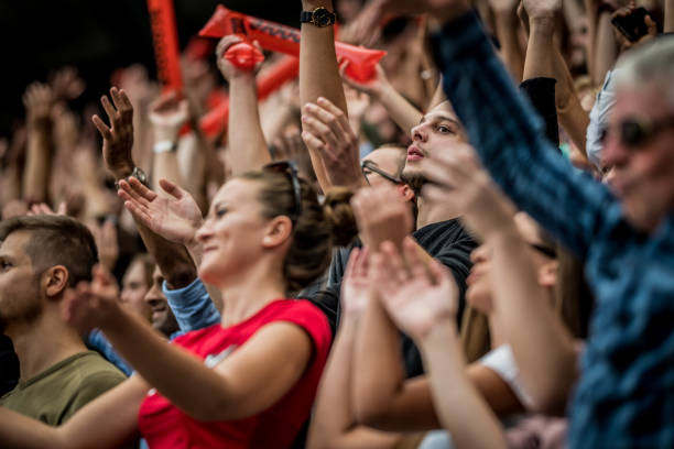 istock Crowd cheering for their team with arms raised 1128980883
