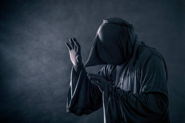 istock Spooky monster in hooded cloak 1128981443