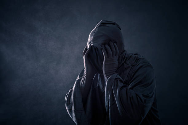 istock Scary figure in hooded cloak 1128982047