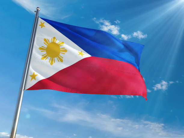 istock Philippines National Flag Waving on pole against sunny blue sky background. High Definition 1128982130