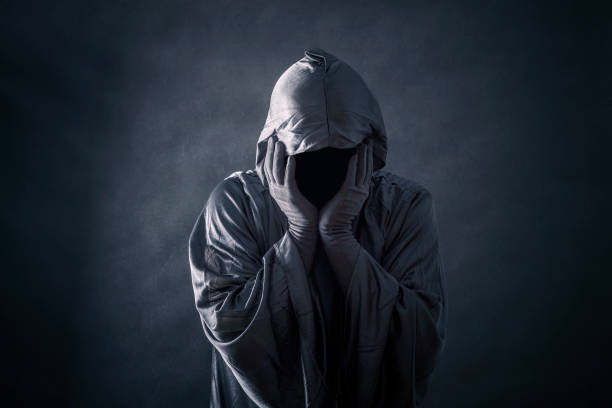istock Scary figure in hooded cloak 1128982239