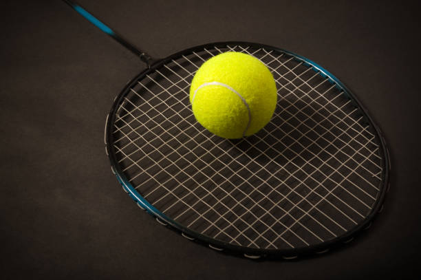 istock tennis ball and racket on dark 1128982753