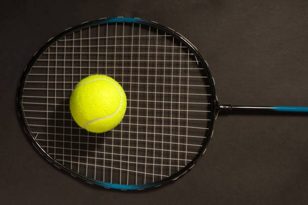 istock tennis ball and racket on dark 1128982796