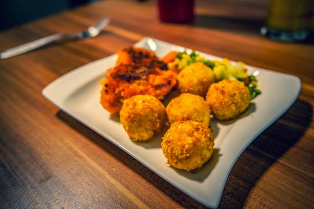 istock Chicken, potato balls and healthy salad 1128983420