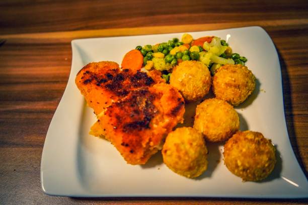 istock Chicken, potato balls and healthy salad 1128983443