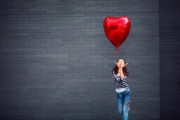 istock Girl with heart shape balloon 1128983789