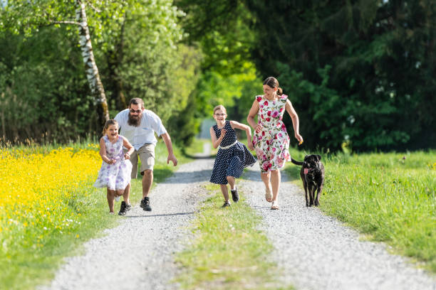 istock Family running outdoors with the dog 1128984168