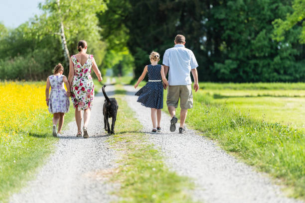 Family walking outdoors with the dog