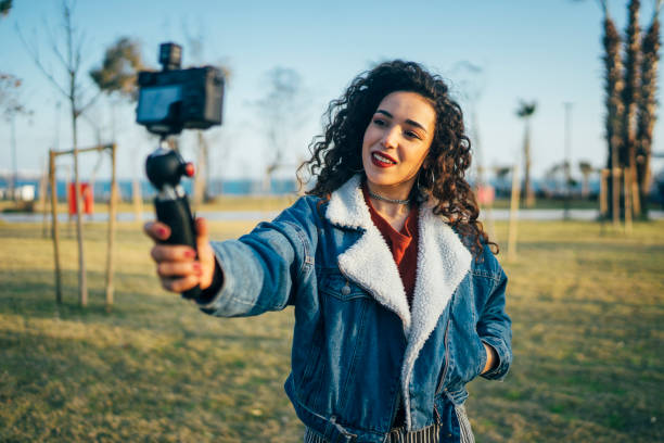 istock Young woman on a vacation vlogging 1128985643