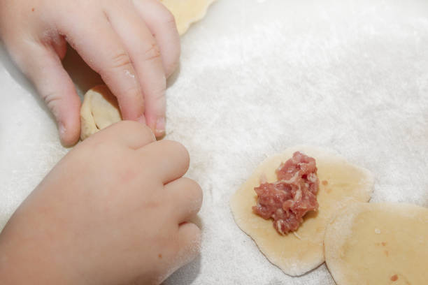 istock Small boy sculpts a homemade ravioli at home 1128989568