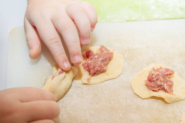 istock Small boy sculpts a homemade ravioli at home 1128989624