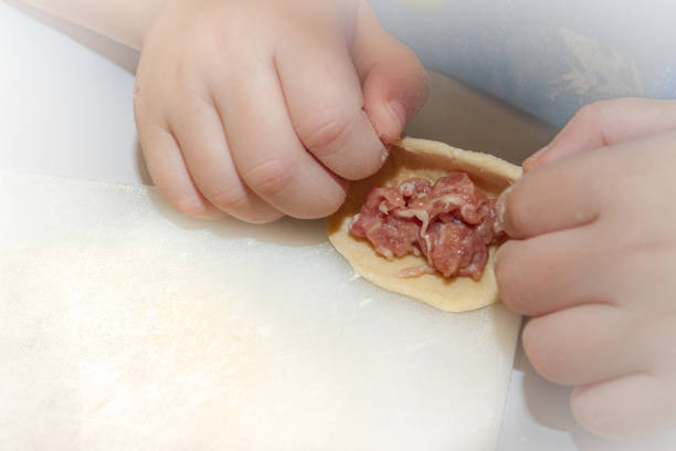 istock Small boy sculpts a homemade ravioli at home 1128989626