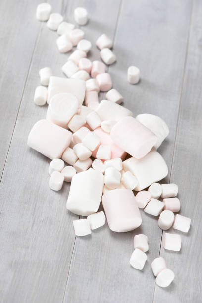 Various white marshmallows on the grey wooden table