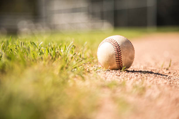 baseball season is here.  weathered ball on field. - baseball field grass baseballs imagens e fotografias de stock