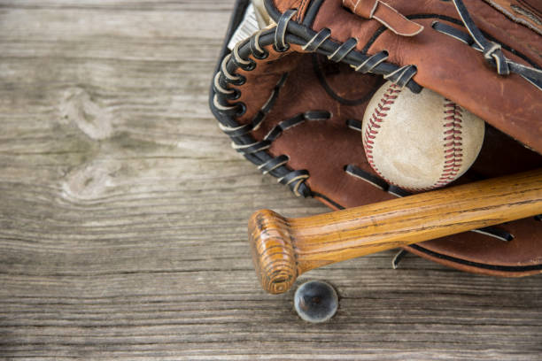 saison de baseball est ici.  bat, gant et boule sur le banc de l’étang-réservoir. - dugout baseball bench bat photos et images de collection