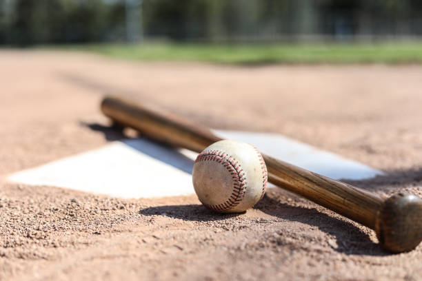 istock Baseball season is here.  Bat and ball on home plate. 1128991564
